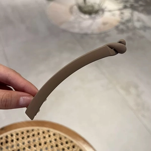 Close-up of a matte brown banana hair clip with an ergonomic curved design for women