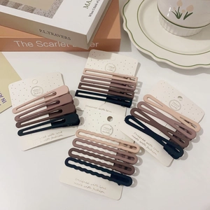 Set of matte earth-toned hair clips in rectangle and teardrop shapes on display card