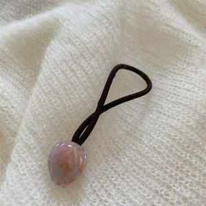 Vue détaillée d'un pendentif tulipe en résine rose avec gravure NICE sur un chouchou marron