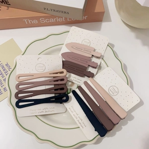 Matte earth-tone hair clip set including oval and pointed styles on display tray