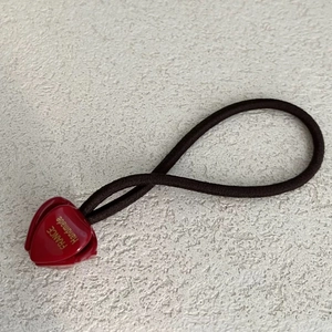Détail d'un charm cœur rouge avec texte France Handmade sur élastique à cheveux noir