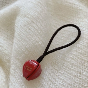 Gros plan sur la perle tulipe rouge faite main avec gravure dorée France sur élastique noir