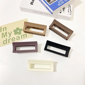 Detailed top view of five matte rectangular hair claws in various colors on white background