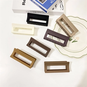 Set of 7 matte rectangular hair claw clips in various earth tones on a white surface