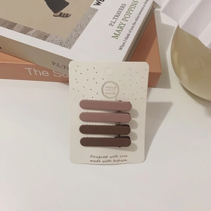 Set of four matte brown hair clips in gradient earth tones on a white display card