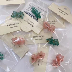 Détail de petites pinces à cheveux fleur de camélia en résine avec perles et fini mat