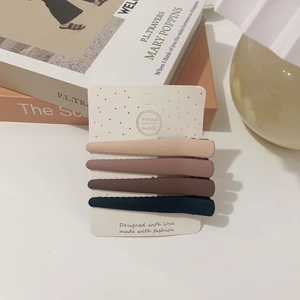Detailed view of 4-piece matte duckbill hair clips set in neutral earth tones