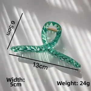 Macro detail of green translucent hair claw with geometric texture and 13cm size mark