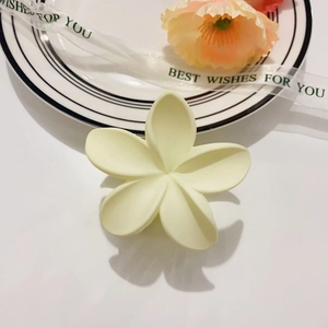Primer plano de una pinza para el cabello con flor amarilla mate en una mesa