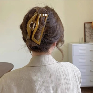Grande molletta per capelli quadrata in acrilico ambra indossata su uno chignon