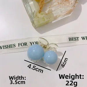 Detail of blue cherry hair claw clip with gold spring and measurements 4.5cm by 4cm