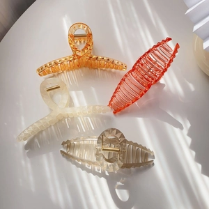 Minimalist translucent resin shark hair claw clips in four colors with elegant shadow lighting