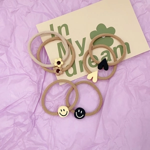 Detailed view of elastic hair ties featuring cute floral, heart, and smiley resin charms