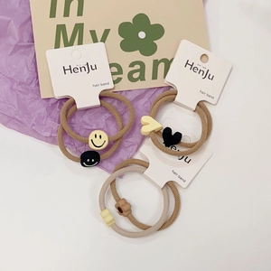 Detail of minimalist elastic hair ties featuring cute smile, heart, and flower resin charms