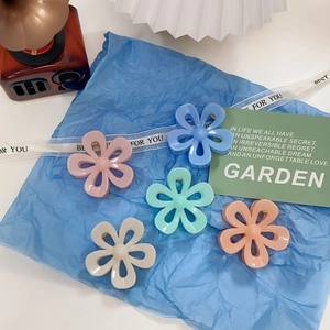 Five-piece set of matte floral shark hair claws in pastel colors on blue paper
