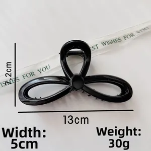 Detail view of large black 13cm hair claw clip with minimalist geometric cutout design