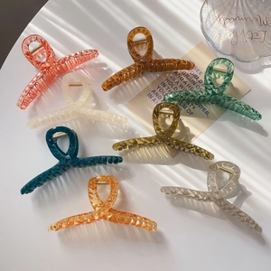 Macro detail of large translucent hair claws with geometric diamond texture in various colors