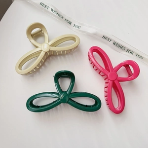 Set of large bow-shaped hair claw clips in cream yellow, dark green, and magenta pink