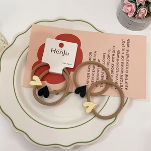 Close-up of heart charm hair ties with smile engraving on elegant ceramic plate