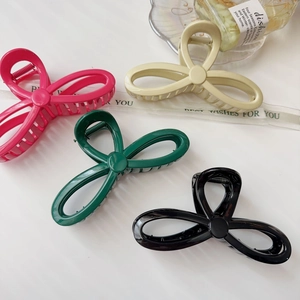 Set of four bow-shaped hair claw clips in assorted glossy colors for elegant styling