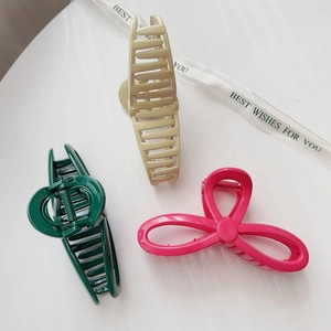 Three-piece large hair claw clips in green, cream, and pink with various hollow designs