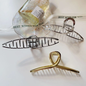 Detail showing high-polish gold and silver metal hair claws for elegant hair styling