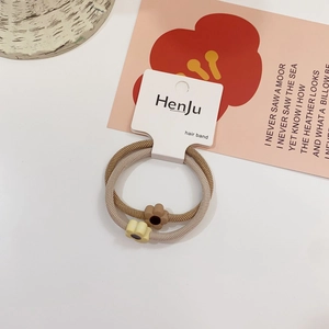 Detail of minimalist flower hair bands in brown and beige colors on branded card