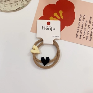 Detail of two elastic hair bands with yellow and black heart smile charms on card