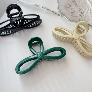 Three elegant matte hair claws in black, dark green and cream beige for women's styling
