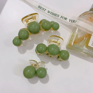 Detailed set of three green acrylic hair claws in large and small sizes with pearl accents