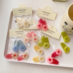 Detailed view of colorful resin flower hair clips in various pastel shades on a white tray