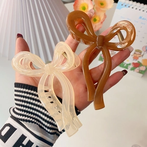 Cream and brown bow hair claws in glossy resin for elegant hairstyles