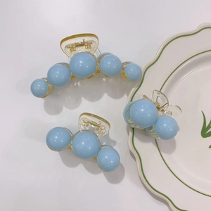 Set of light blue pearl hair claws in three styles on white background for women