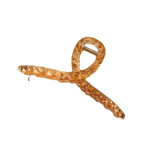 Amber translucent shark hair claw clip with geometric faceted resin design on white background
