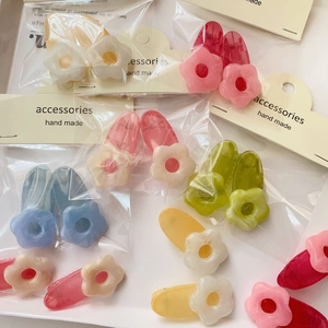 Detail of colorful floral hair clips on handmade card display in clear packaging