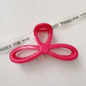 Close-up of a glossy rose red hair claw clip with a stylish interlaced ring design