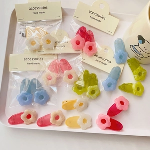 Detail of floral resin hair clips in pastel colors including pink, yellow and blue