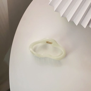 Nahaufnahme der cremefarbenen Haarklammer aus Harz mit minimalistischem Cut-out-Design
