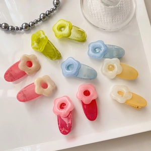 Set of colorful floral hair clips in resin material arranged on white decorative tray