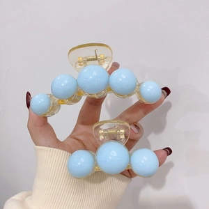 Detailed comparison of large and small amber acrylic hair claws with blue pearl accents