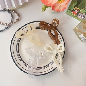 Detailed set of four jelly colored bow hair claws in transparent cream and coffee shades