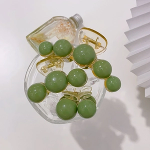 Set of avocado green pearl hair claws in various sizes with transparent resin base