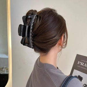 Pince à cheveux noire brillante grand format pour cheveux épais sur chignon bas