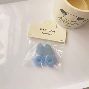 Detail of light blue floral resin hair clips with marble texture on handmade card packaging