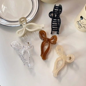 Detailed top view of five jelly-colored resin bow hair claws in various neutral shades