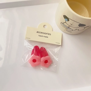 Detail of pink flower hair clips for women and girls on display card with beige mug backdrop