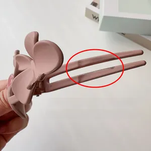 Gros plan sur la pince à cheveux papillon rose mat avec finition givrée