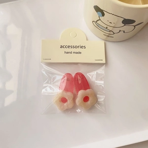 Close-up of pink and white flower hair clips set in handmade cardboard packaging
