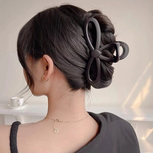 Elegant large matte black bow hair claw clip styled on a brunette bun updo accessory