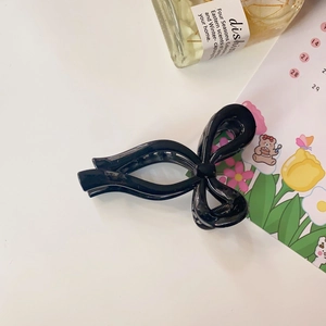 Glossy black bow-shaped claw clip featuring double-layered design and a polished finish